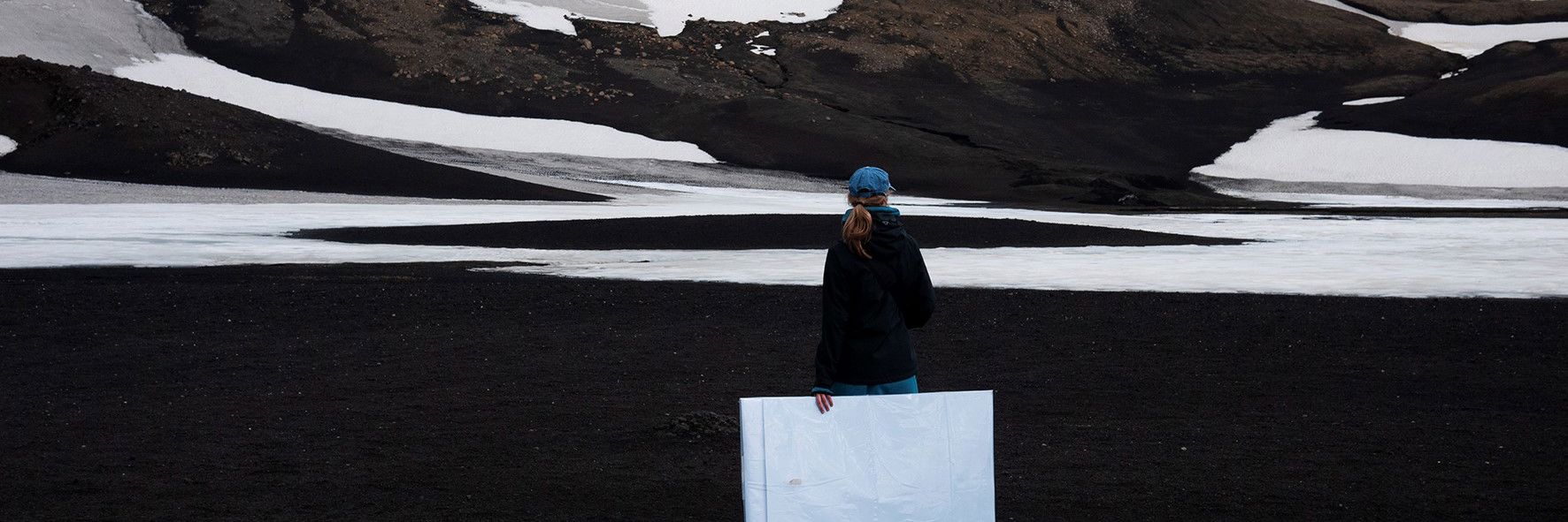 Kvinde foran gletsjer-landskab i Island