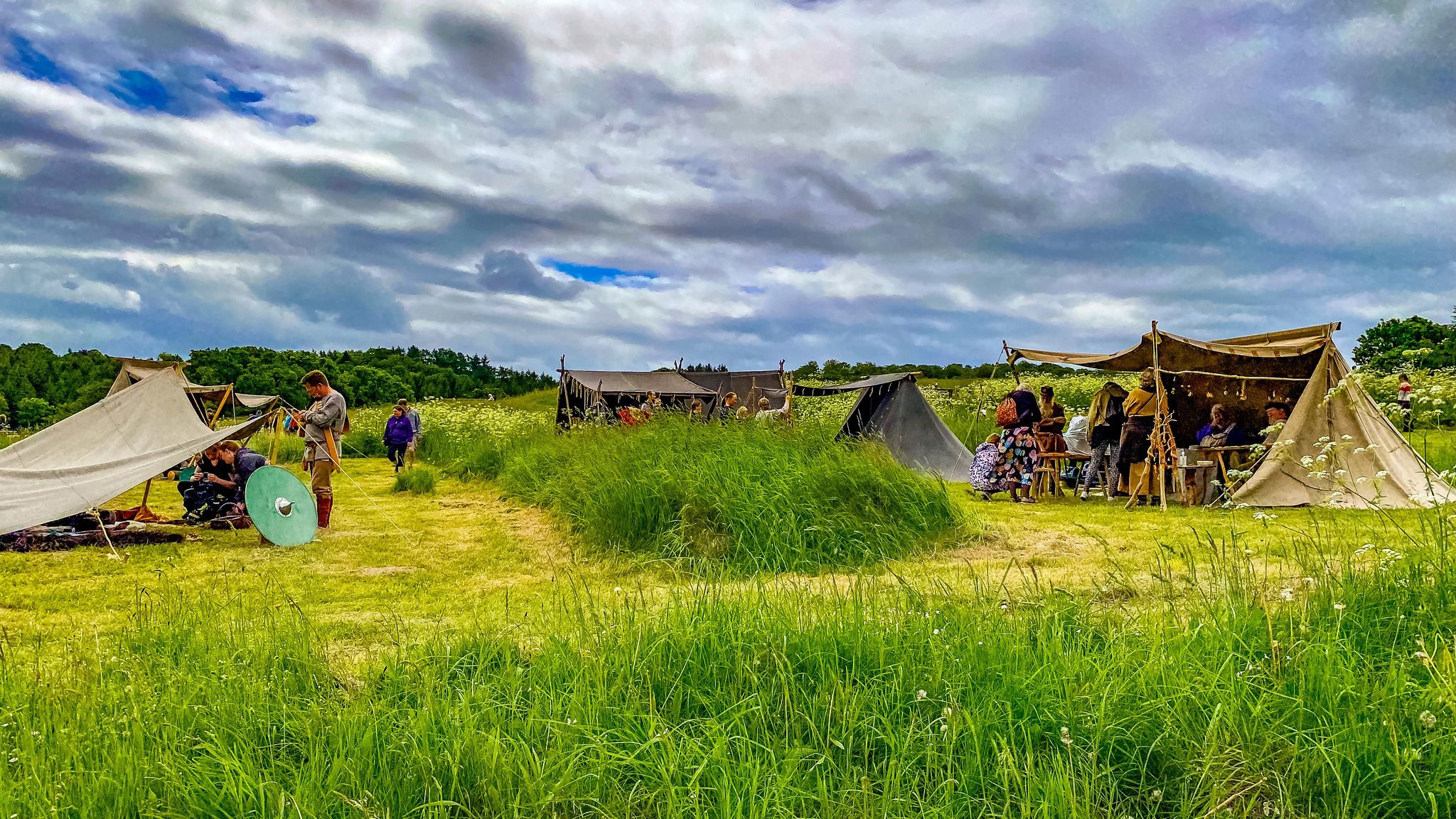Telte med jernalderhåndværkere på græsmark